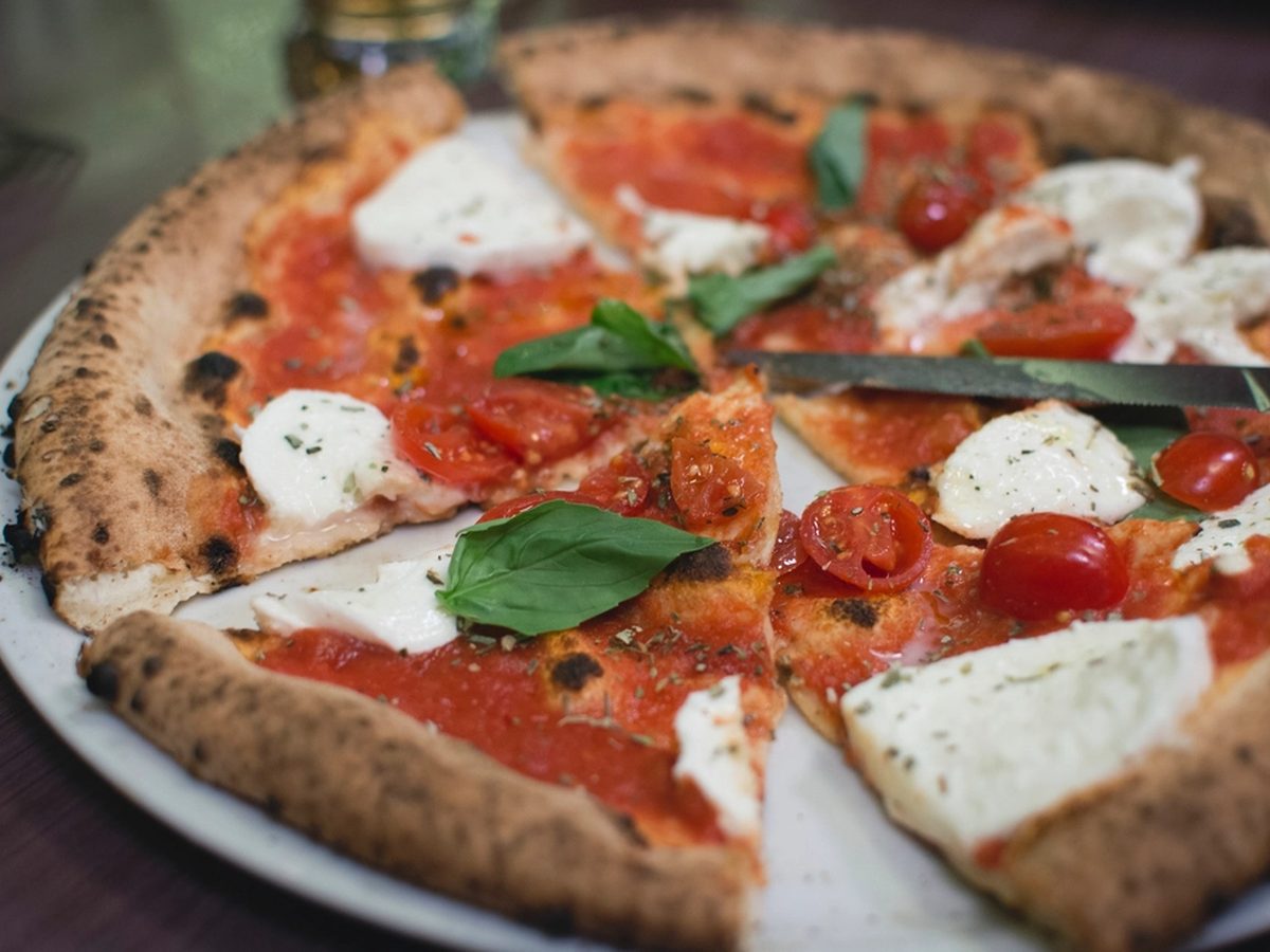 Pizza margherita con mozzarella fresca, pomodorini e basilico