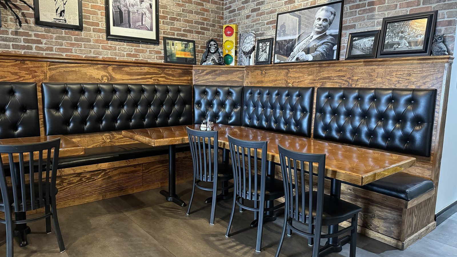 Sala di una pizzeria con tavoli in legno e divanetti